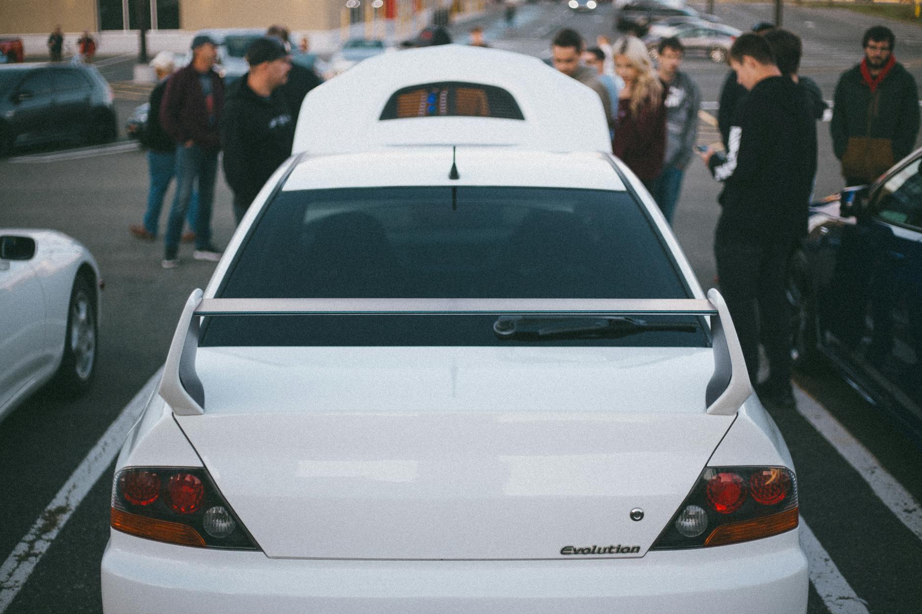 Białe sportowe auto na parkingu podczas zlotu samochodowego