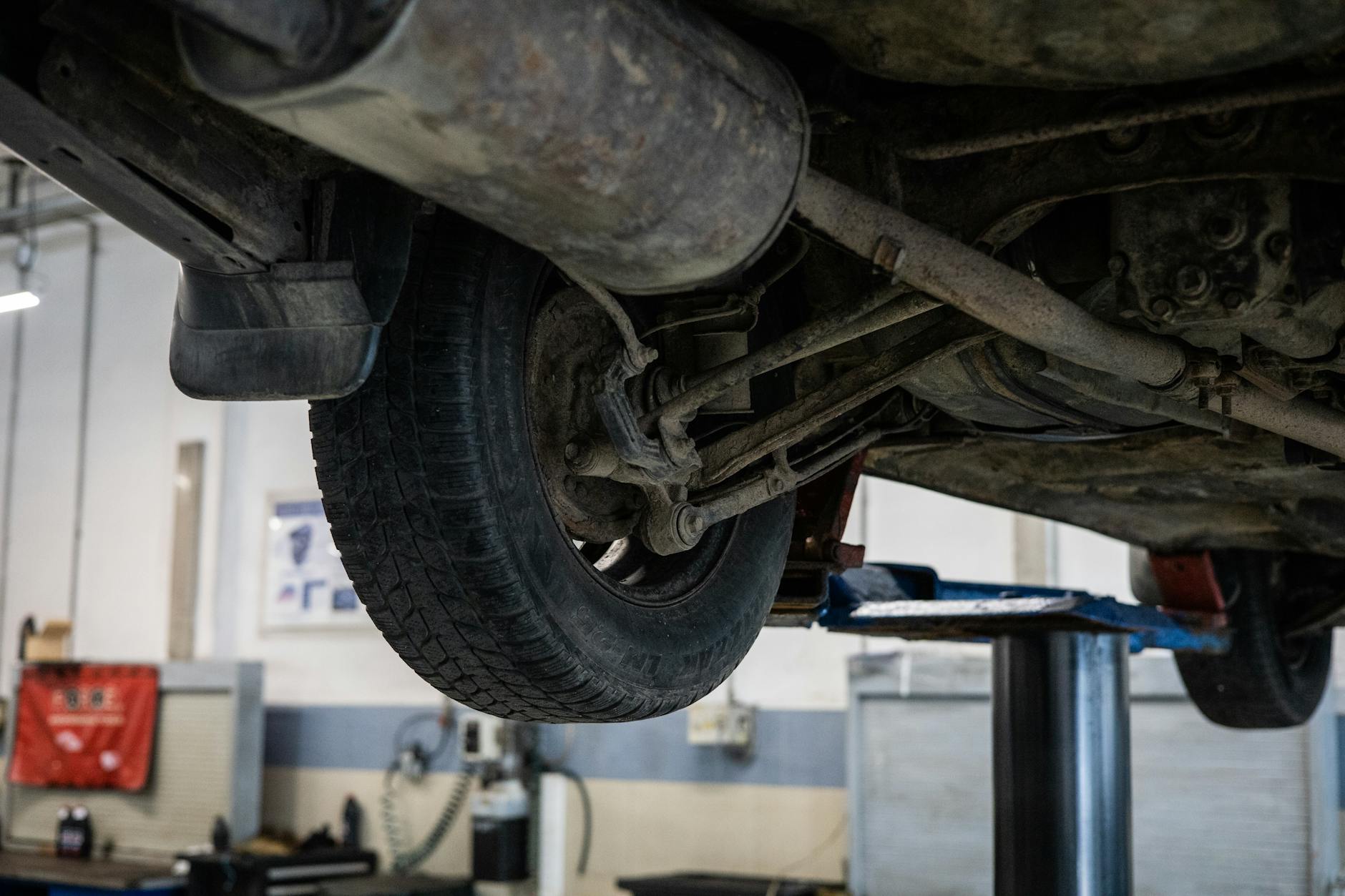 Mechanik ogląda podwozie samochodu na podnośniku w warsztacie
