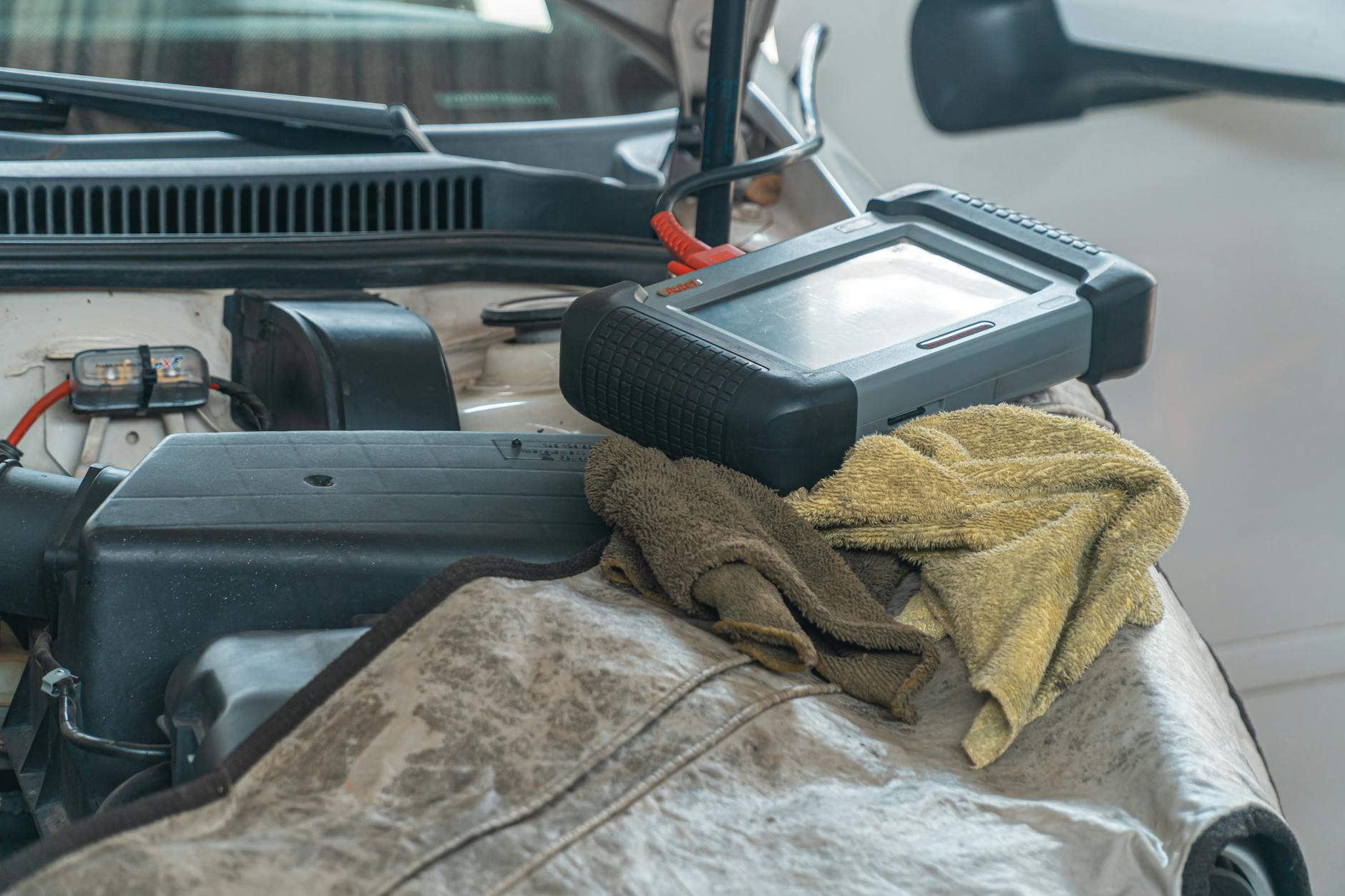 Tester diagnostyczny podłączony do silnika samochodu w warsztacie