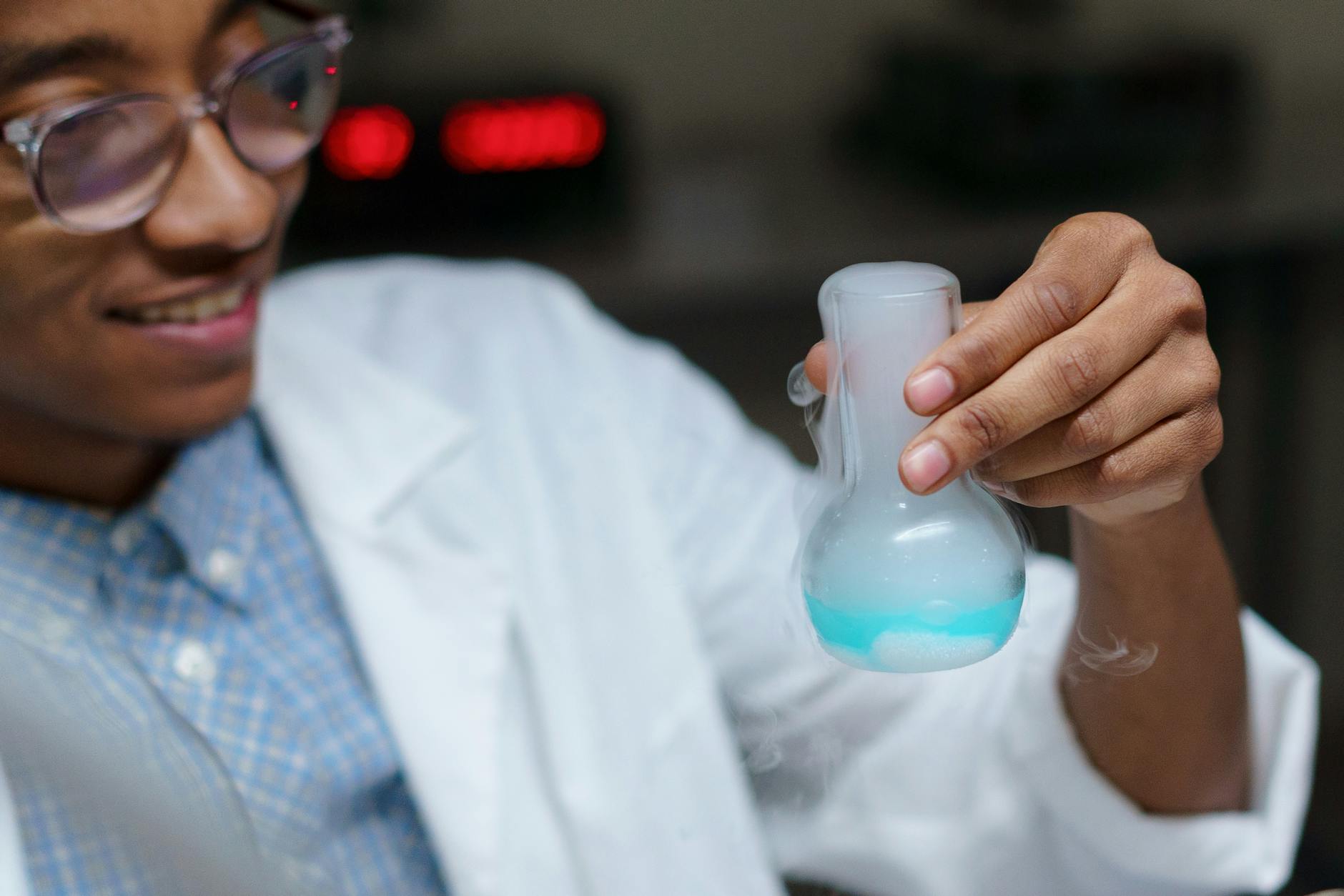 Uczeń w laboratorium uważnie obserwuje reakcję chemiczną