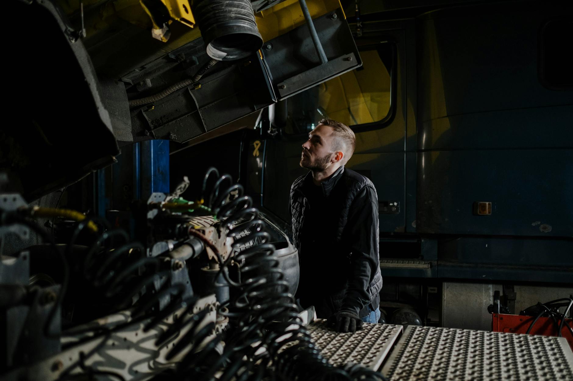 Mechanik ciężarówki ogląda silnik w warsztacie