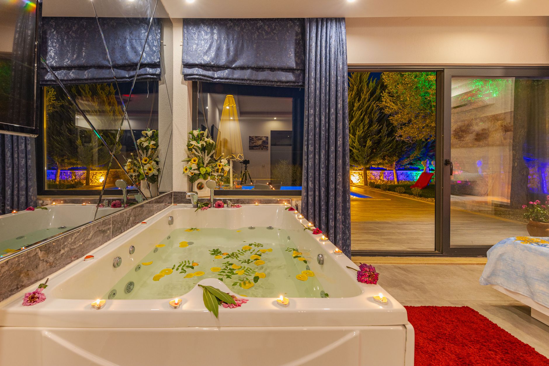 Luksusowe jacuzzi w domu z płatkami róż i zapalonymi świecami