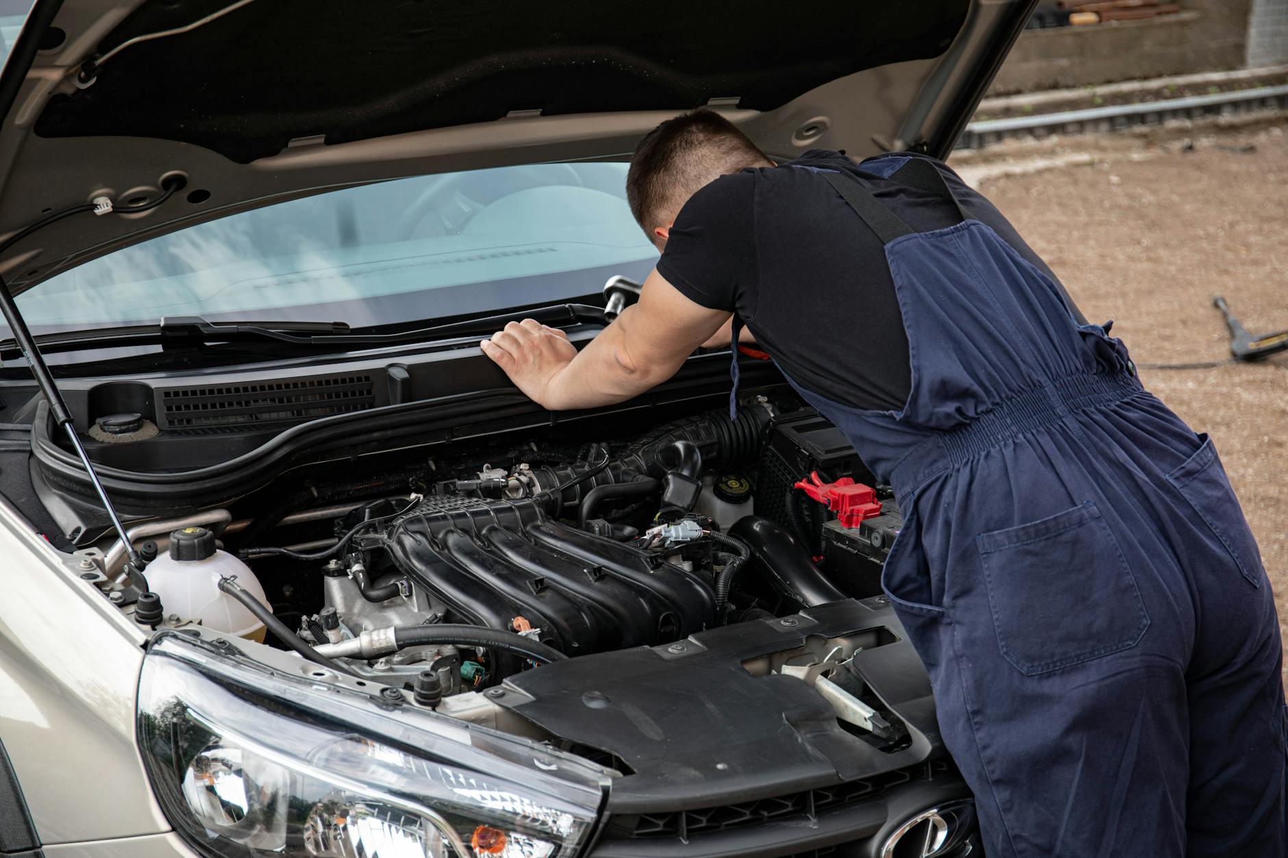 Mechanik na zewnątrz sprawdza silnik samochodu po problemach z paliwem